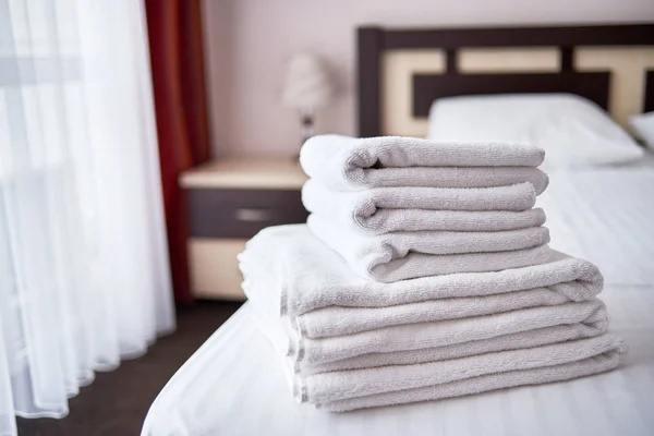 Modern otelde yatak çarşafı üzerinde beyaz temiz banyo havlusu Yığını olmak — Stok fotoğraf