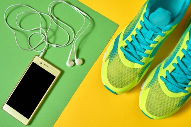 Renkli bac spor koşu ayakkabıları ve mobil cep telefonu çifti