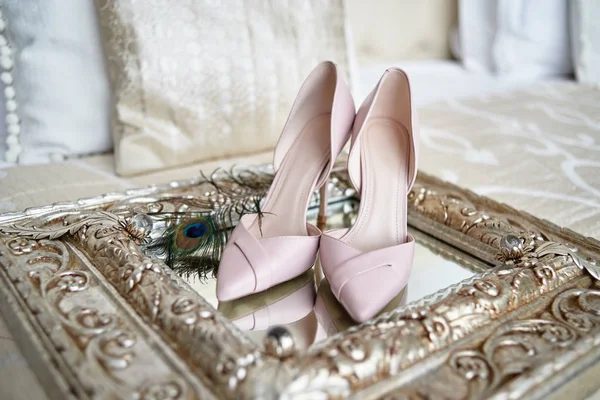Красивые розовые туфли невесты на высоких каблуках и павлинье перо на — стоковое фото