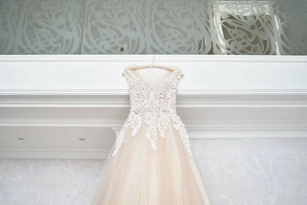 Wunderschönes beige besticktes Brautkleid, das am Kleiderbügel agai hängt — Stockfoto