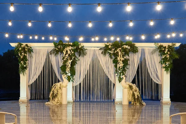Ночная свадебная церемония с аркой, орхидеи цветы, пальмовые листья, с — стоковое фото