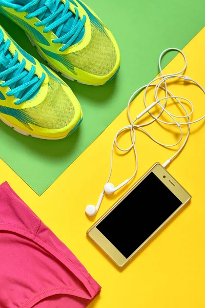 Sport shoes, female top bra, smartphone and skipping rope on col