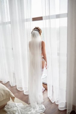 Iç çamaşırı ve uzun peçe ayakta n güzel gelin portresi