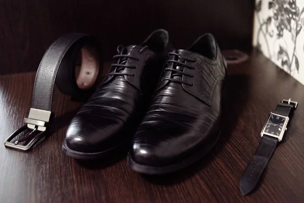 Közelről fekete férfi cipők, öv és az órák a fa asztal Bac — Stock Fotó