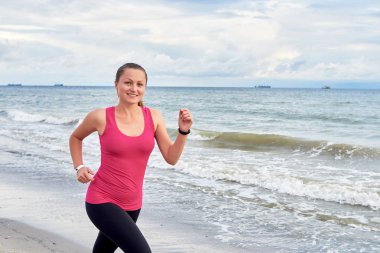 Genç fitness kadın koşucu deniz kenarında çalışan, uzay kopyalamak. Kız 