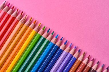 Pembe pastel arka plan üzerinde renkli kalemler, yakın. Colorf seti