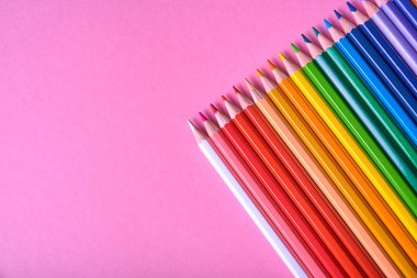 Pembe pastel arka plan üzerinde renkli kalemler, yakın. Colorf seti