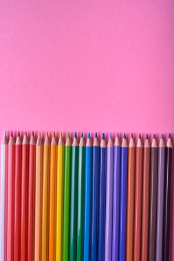 Pembe pastel arka plan üzerinde renkli kalemler, yakın. Colorf seti