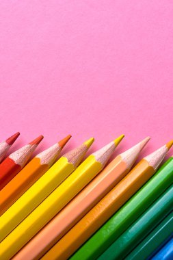 Pembe pastel arka plan üzerinde renkli kalemler, yakın. Colorf seti