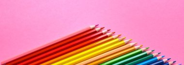 Pembe pastel arka plan üzerinde renkli kalemler, yakın. Colorf seti