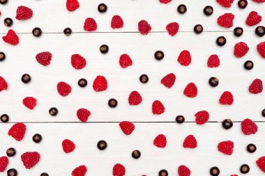 Olgun tatlı ahududu ve beyaz ahşap backgroun siyah frenk üzümü