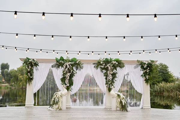 Роскошная свадебная арка, украшенная пальмовыми листьями, цветами орхидей , — стоковое фото