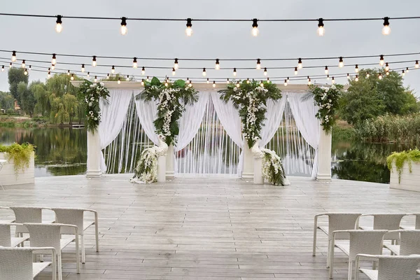 Место для свадебной церемонии со свадебной аркой, украшенной пальмой — стоковое фото