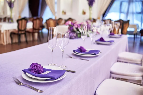 Table setting with white plates, flowers, wineglasses and cutler