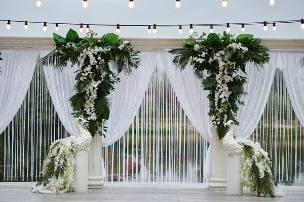 Роскошная свадебная арка, украшенная пальмовыми листьями, цветами орхидей , — стоковое фото