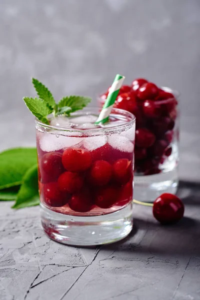 Fresh cherry lemonade with ice, mint and paper straw in sparklin — Stock Photo, Image