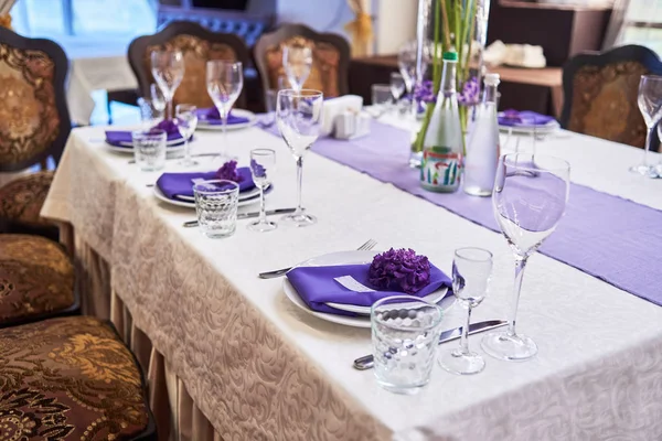 Обстановка столу з білими тарілками, келихами, столовими приборами та квіткою — стокове фото