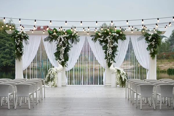 Место для свадебной церемонии со свадебной аркой, украшенной пальмой — стоковое фото