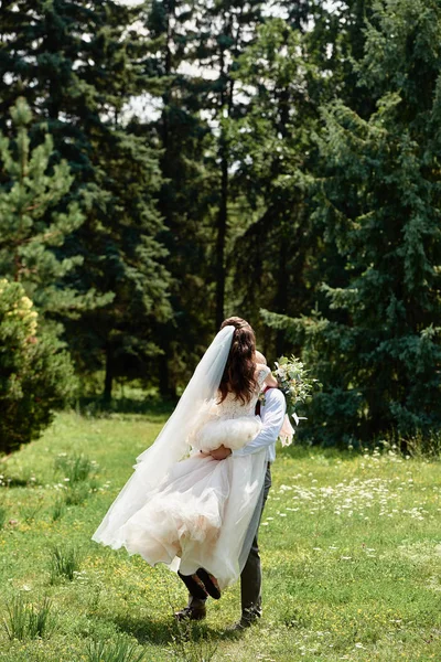 Feliz novia y novio abrazando y caminando en el jardín en la boda d —  Fotos de Stock