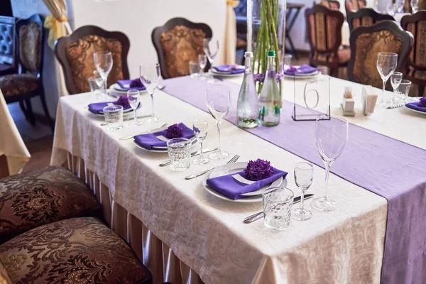 Обстановка столу з білими тарілками, келихами, столовими приборами та квіткою — стокове фото