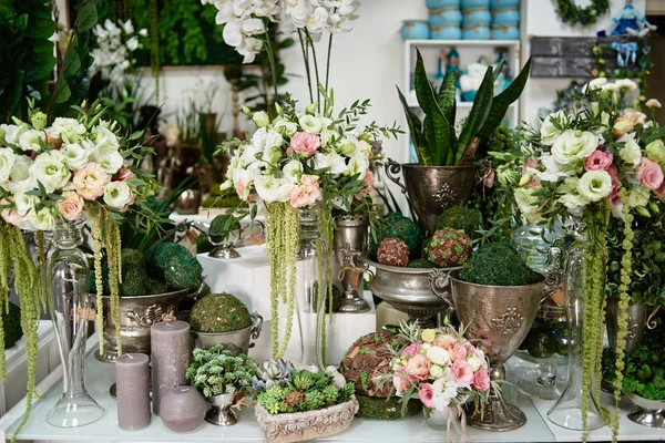 Muitas flores e velas na mesa na florista loja, espaço de cópia. S — Fotografia de Stock