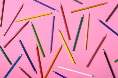 Pembe pastel arka plan üzerinde renkli kalemler, yakın. Colorf seti