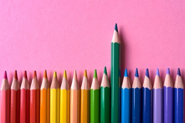 Pembe pastel arka plan üzerinde renkli kalemler, yakın. Colorf seti