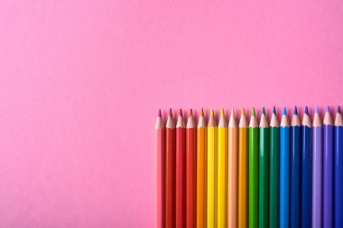 Pembe pastel arka plan üzerinde renkli kalemler, yakın. Colorf seti