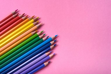 Pembe pastel arka plan üzerinde renkli kalemler, yakın. Colorf seti