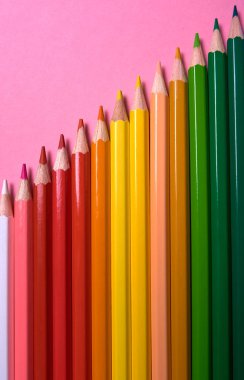 Pembe pastel arka plan üzerinde renkli kalemler, yakın. Colorf seti