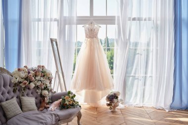 Pencereye karşı askıda asılı güzel bej gelinlik i