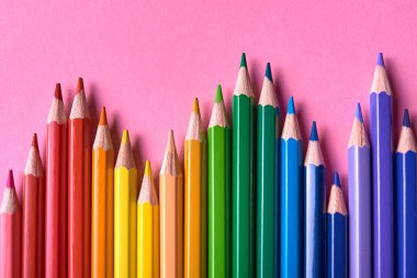 Pembe pastel arka plan üzerinde renkli kalemler, yakın. Colorf seti