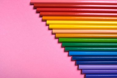 Pembe pastel arka plan üzerinde renkli kalemler, yakın. Colorf seti