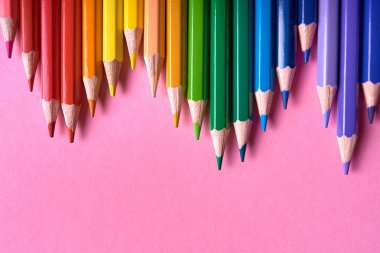 Pembe pastel arka plan üzerinde renkli kalemler, yakın. Colorf seti