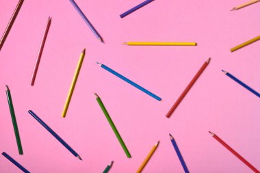 Pembe pastel arka plan üzerinde renkli kalemler, yakın. Colorf seti