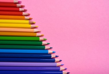 Pembe pastel arka plan üzerinde renkli kalemler, yakın. Colorf seti