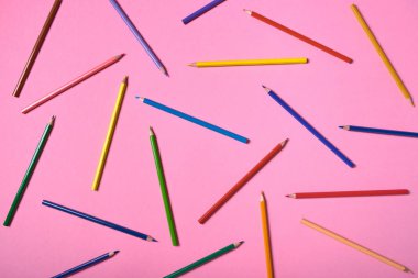 Pembe pastel arka plan üzerinde renkli kalemler, yakın. Colorf seti