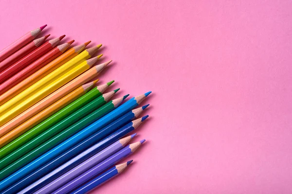Pembe pastel arka plan üzerinde renkli kalemler, yakın. Colorf seti