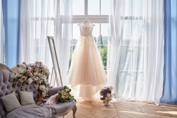 Pencereye karşı askıda asılı güzel bej gelinlik i