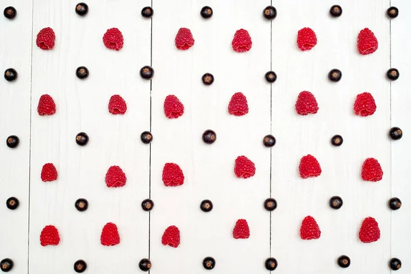 Olgun tatlı ahududu ve beyaz ahşap backgroun siyah frenk üzümü