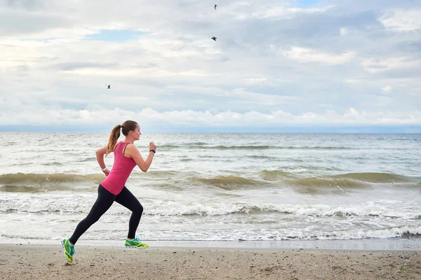 Młoda kobieta fitness biegacz działa na wybrzeżu, przestrzeń kopiowania. Dziewczyna — Zdjęcie stockowe