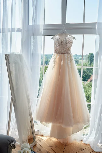 Vestido de noiva bonito bege bordado pendurado no cabide agai — Fotografia de Stock