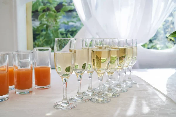 Sparkling glassware with  champagne and juice on dinner table in — Stock Photo, Image