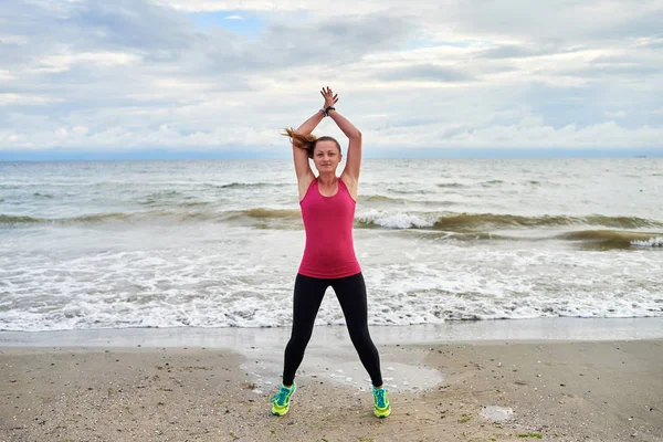 Mutlu fitness kadın atlama jacks veya yıldız atlama egzersiz yapıyor