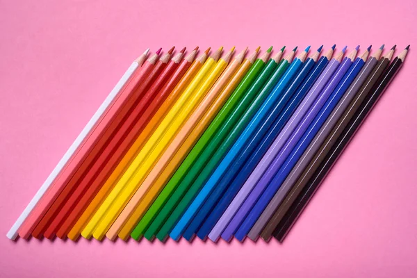 Кольорові олівці на рожевому пастельному фоні, крупним планом. Набір кольорів — стокове фото