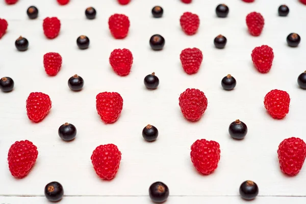 Olgun tatlı ahududu ve beyaz ahşap backgroun siyah frenk üzümü