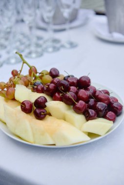 Lüks düğün resepsiyonunda servis masasında dilimlenmiş meyve ve böğürtlen tabağı, fotokopi odası. Restoranda yemek masası.
