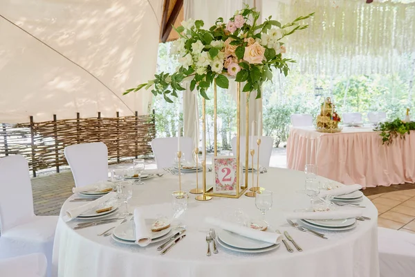 餐桌设置与白盘餐巾 餐具和花卉在桌子上 复制空间 婚礼接待处的位置设置 饭桌在餐馆招待客人 — 图库照片