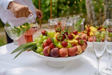 Lüks düğün resepsiyonunda servis masasında dilimlenmiş meyve ve böğürtlen tabağı, fotokopi alanı. Restoranda yemek masası.