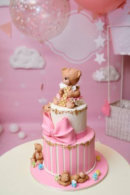 Yay ve hediyelerle süslenmiş yuvarlak katmanlı pembe doğum günü pastası, en üstte bir numaralı ayı, metin için kopyalama alanı